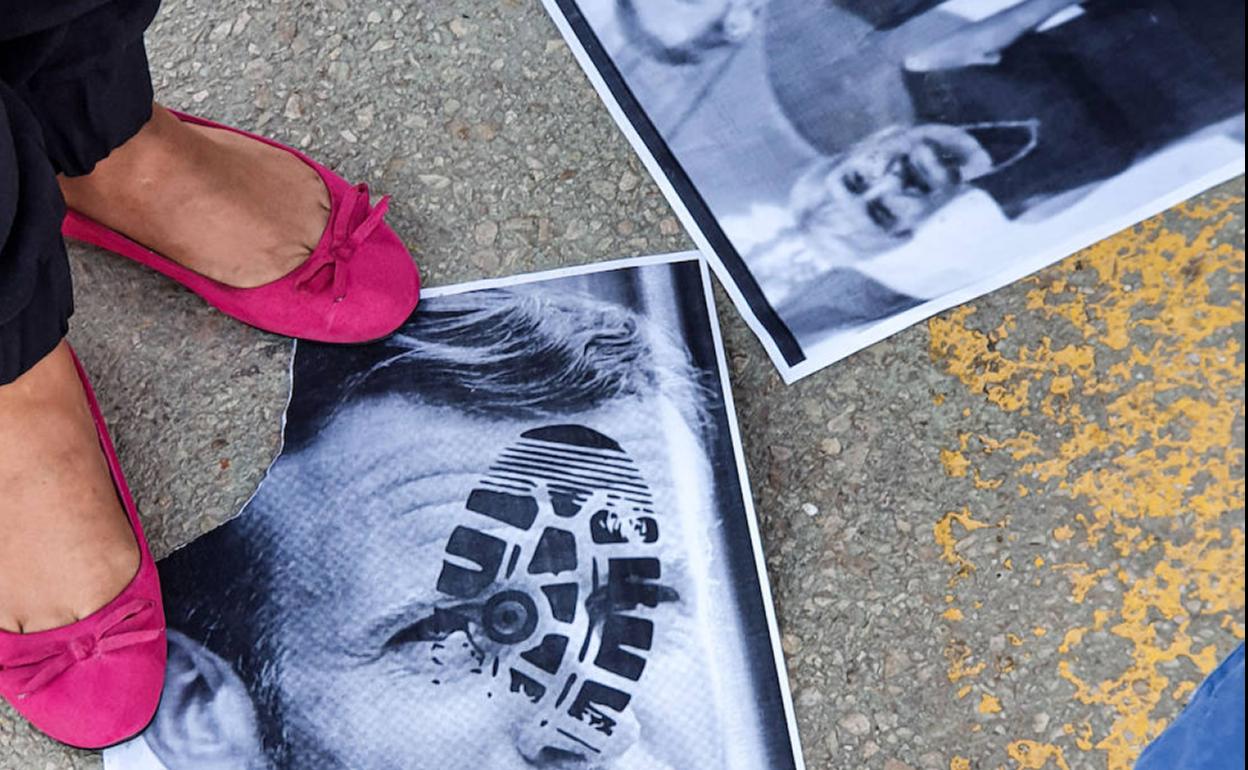 Manifestantes pisan una imagen de Macron en una protesta en Libia.