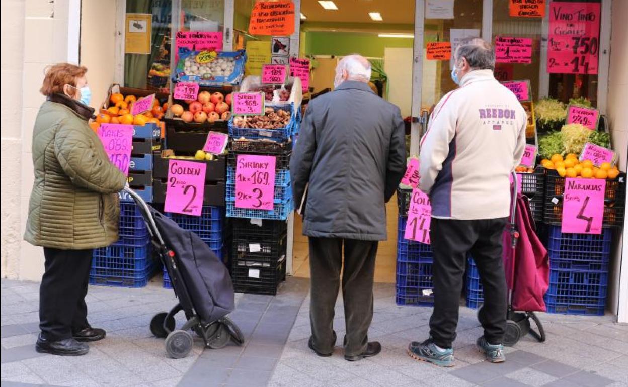 Varios clientes esperan a la puerta de una frutería en la calle Tudela de Valladolid. 