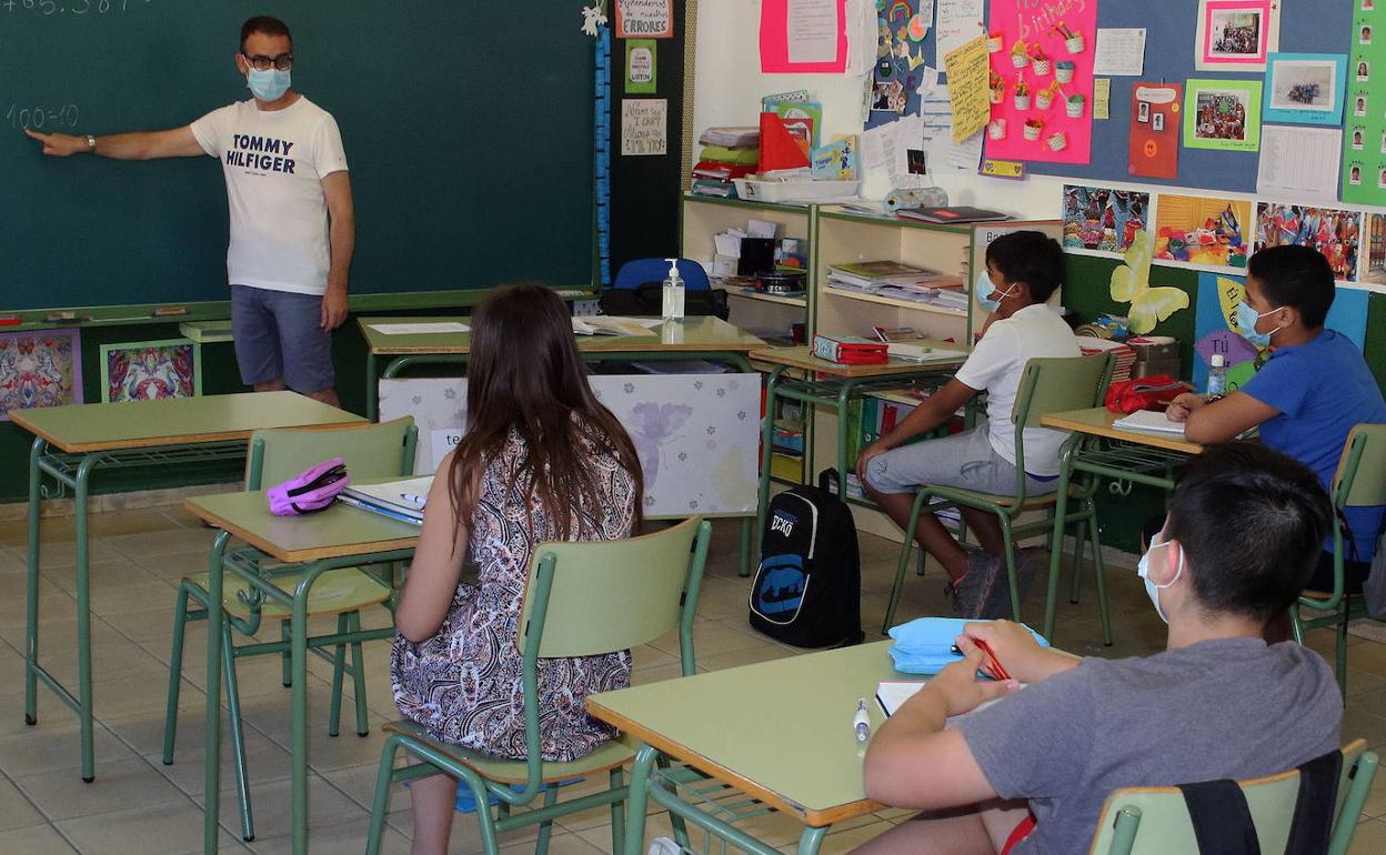 Un grupo de alumnos siguen las explicaciones del profesor.