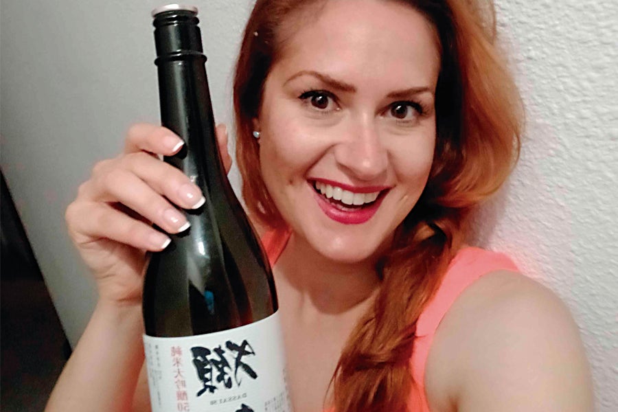 La sumiller con una botella de sake.