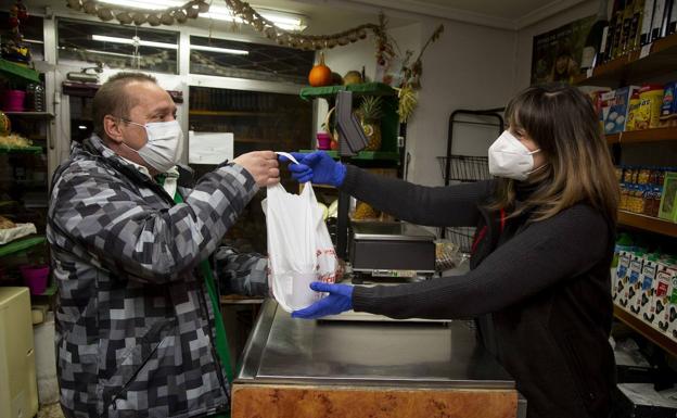 Lolo recibe una bolsa con material solidario en la frutería Beatriz, en la calle San Antonio de Padua. 