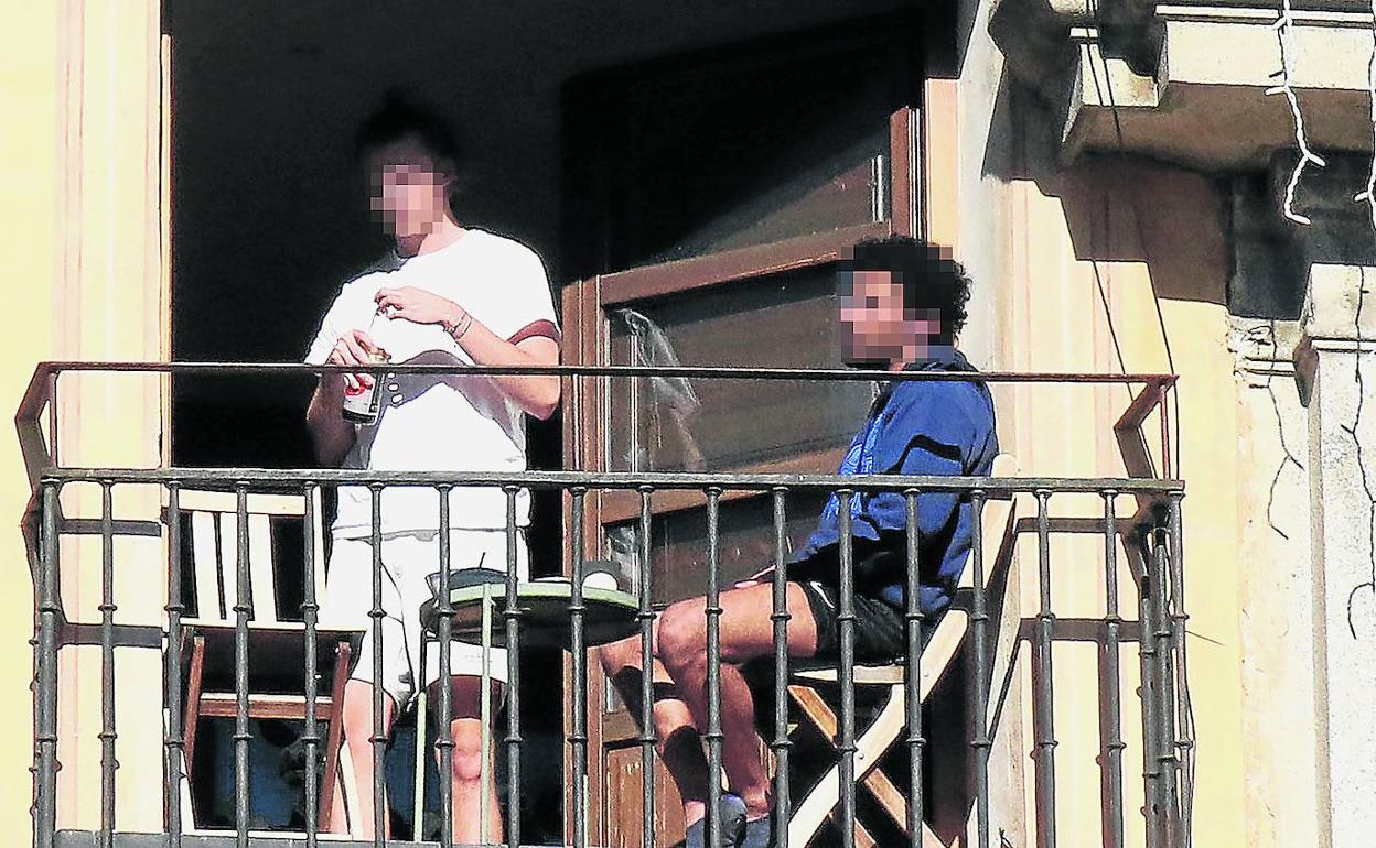 Alumnos universitarios sacan las mesas y las sillas a la terraza de un piso de la Plaza Mayor de Segovia durante la pandemia. 