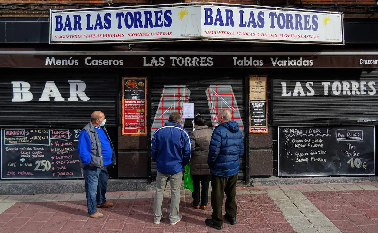 Vecinos congregados ante el bar Las Torres, en la calle Tirso de Molina, donde la familia colocó la esquela. 