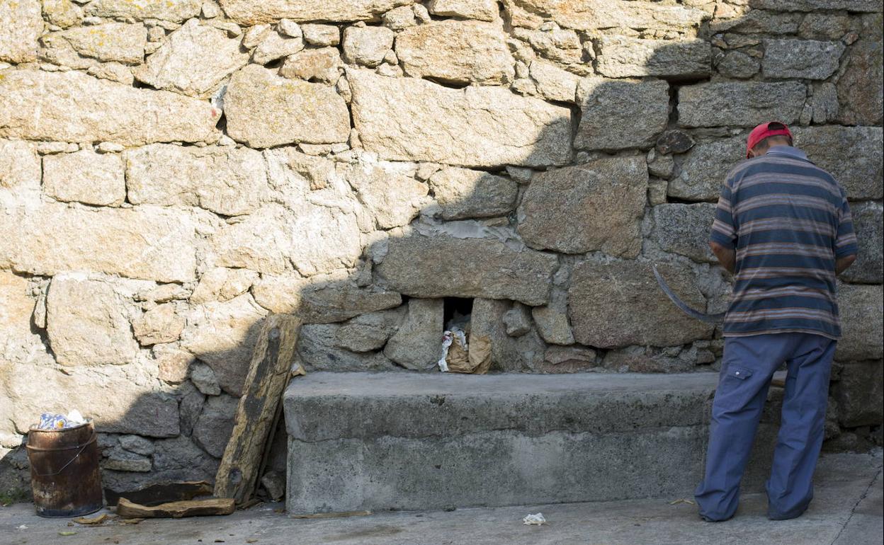 Un hombre, junto a un muro de piedra en Fermoselle, Zamora. 