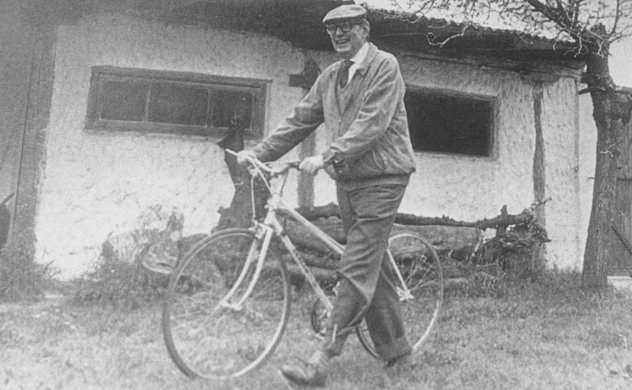 El escritor vallisoletano, muy sonriente, con su inseparable bicicleta en el pueblo burgalés de Sedanoo.