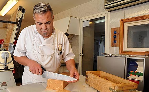 Jesús Fernández corta turrón de almendra en su pastelería.