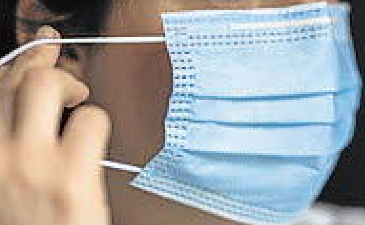 Una mujer con mascarilla. 