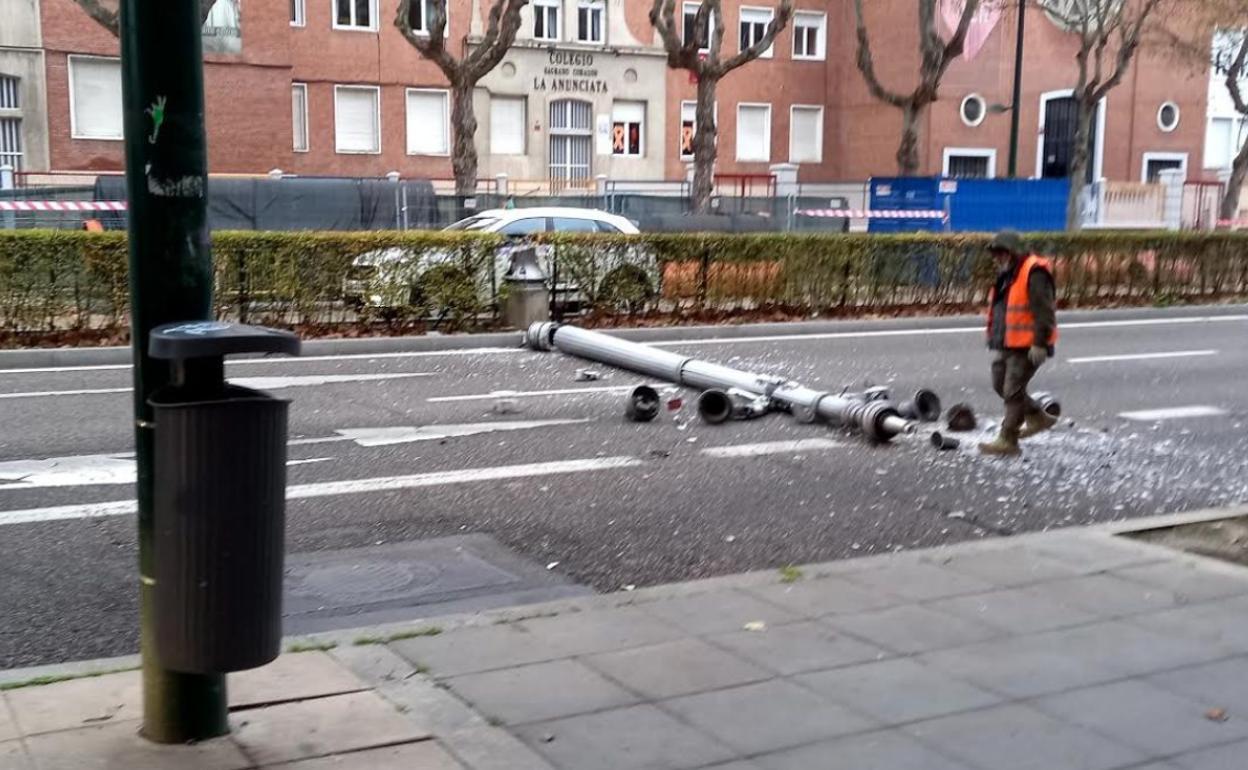 Un operario se acerca a la farola derribada en el Paseo de Zorrilla. 