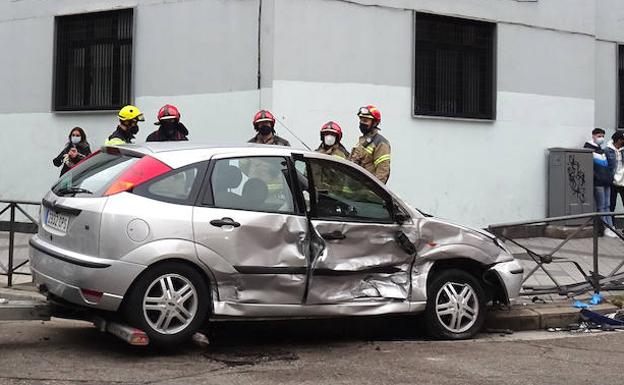 El Ford Focus quedó encajado entre la verja de hierro de la acera.