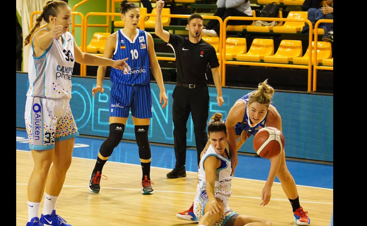Katie Lou Samuelson pugna por un balón con una rival del Campus Promete ante la mirada de Gajic.