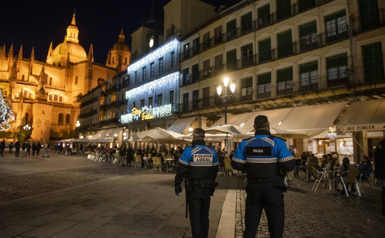 Dos policías locales controlan un parte de la Plaza Mayor y de las terrazas de los bares en la 'Tardebuena' de este jueves. 