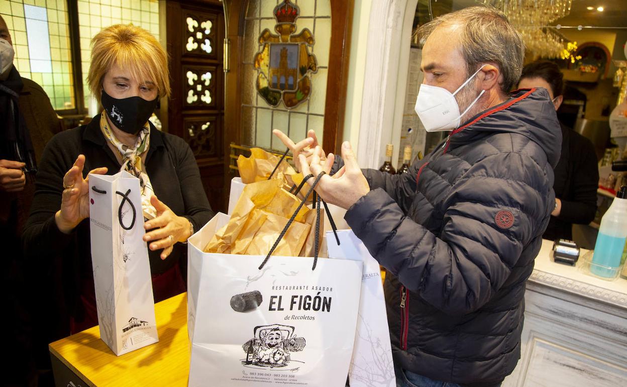 Un cliente recoge unos cuartos de lechazo en El figón de Recoletos.