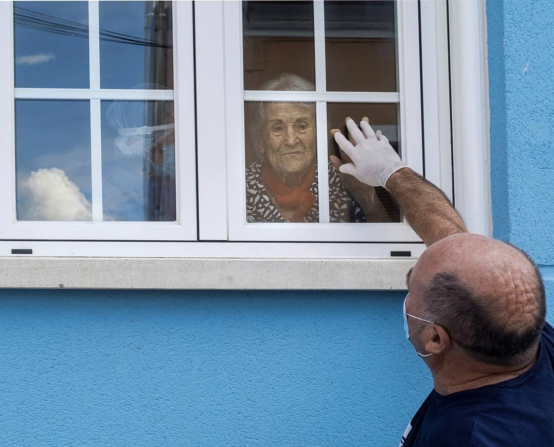 El confinamiento provocó, entre otras cosas, el aislamiento de las personas mayores y les privó de ver a sus seres queridos. El primer día que pudieron verse fue a través de los cristales. En la imagen Alfonso Fernández visita a su Madre Felisa en la Residencia El Rosal del Atrio, en Traspinedo. 