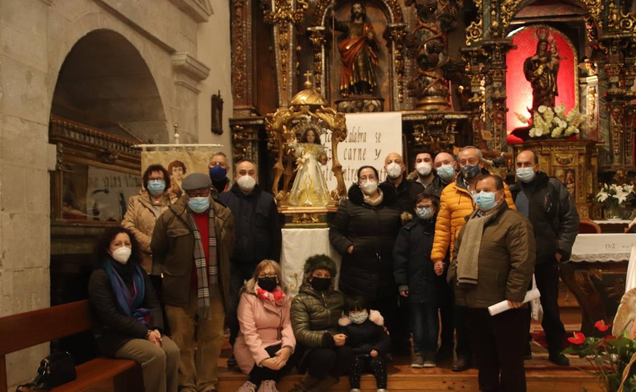 Miembros de la cofradía posan junto a la talla en la iglesia de San Miguel. 