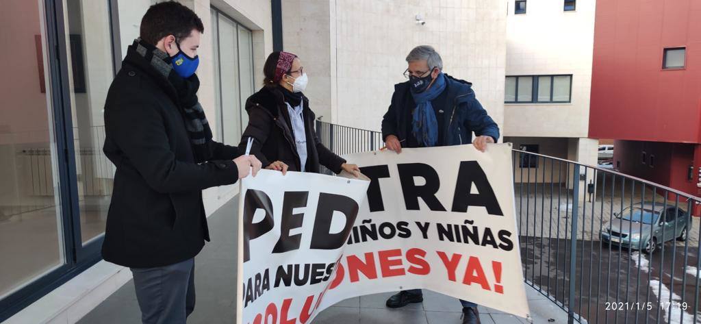 La pediatra, en el centro, retira la pancarta junto al alcalde, Juan Jesús Blanco. 