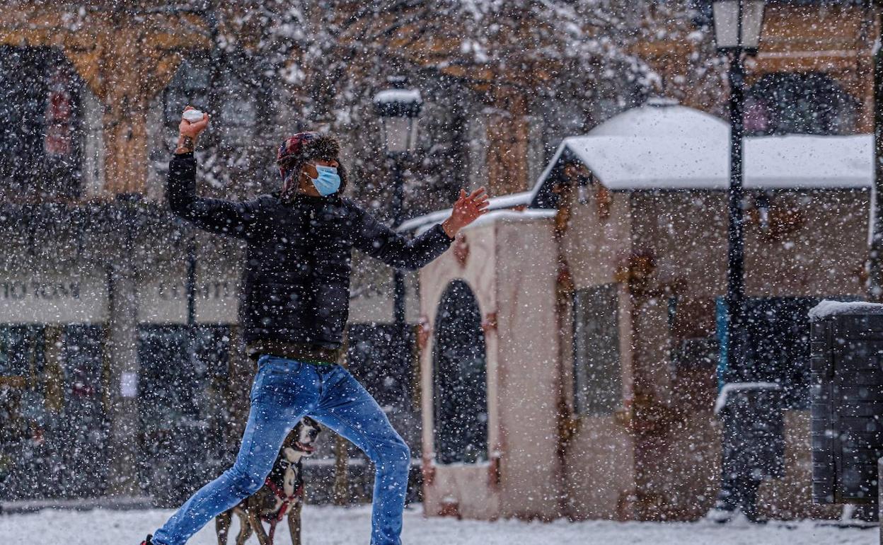 Un hombre se dispone a tirar una bola de nieve en Toledo. 