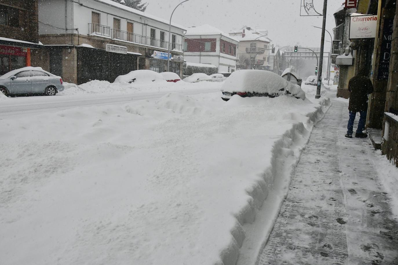 Un vecino de San Rafael, en El Espinar (Segovia), mide el espesor de la capa de nieve caída. 