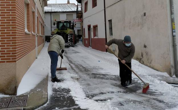 Los vecinos retiran la nieve de una calle en Wamba. 