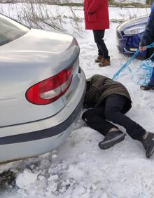 Imagen secundaria 2 - Los vecinos intentan sacar los coches atrapados en la nieve en en el camino Palomares. 