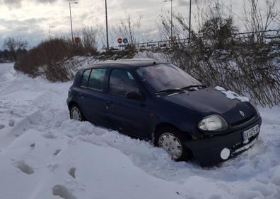 Imagen secundaria 1 - Los vecinos intentan sacar los coches atrapados en la nieve en en el camino Palomares. 