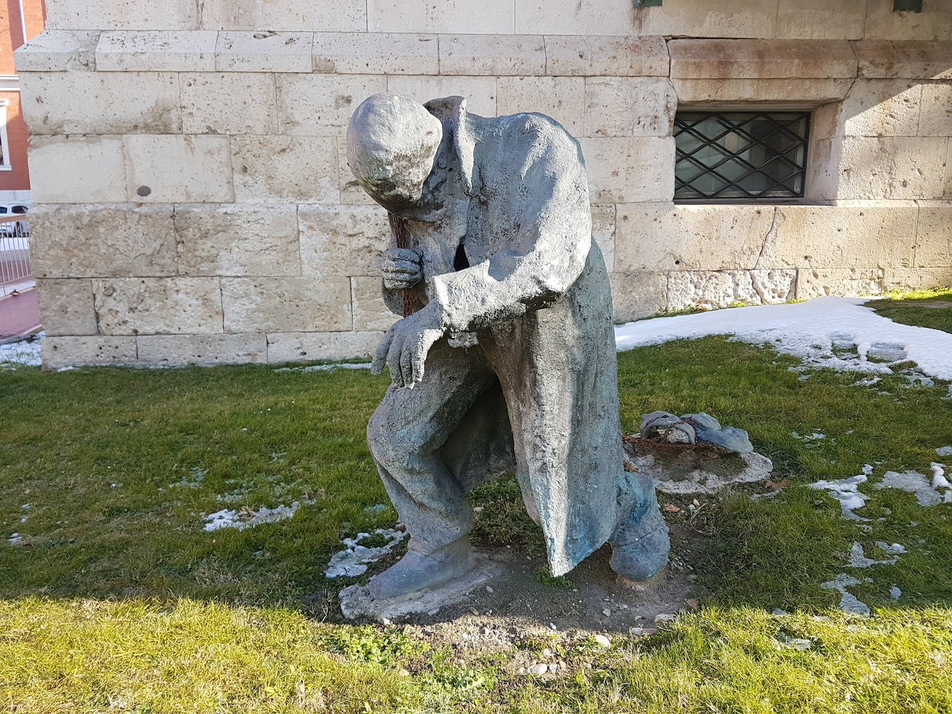 ‘Hombre con máscaras’. Figura en bronce de un hombre apesadumbrado que arrastra unas máscaras tiradas por cadenas. De la serie de ‘Náufragos urbanos’, junto al Hospital Viejo (1999).