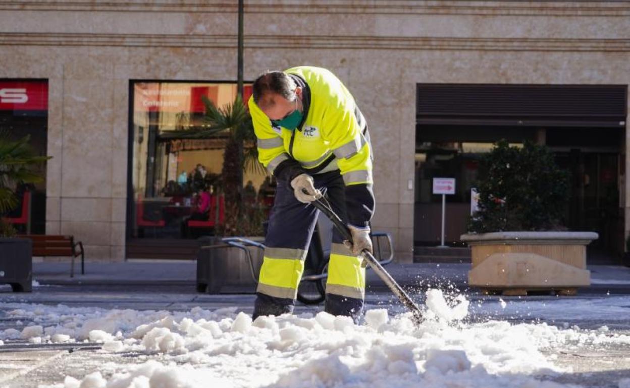Un operario municipal limpia la nieve helada en una acera de Salamanca. 