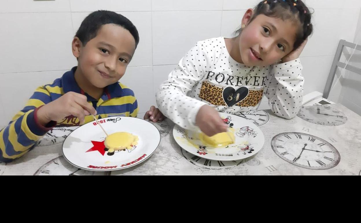 Ángel y Dania elaborando las galletas con forma de carita 