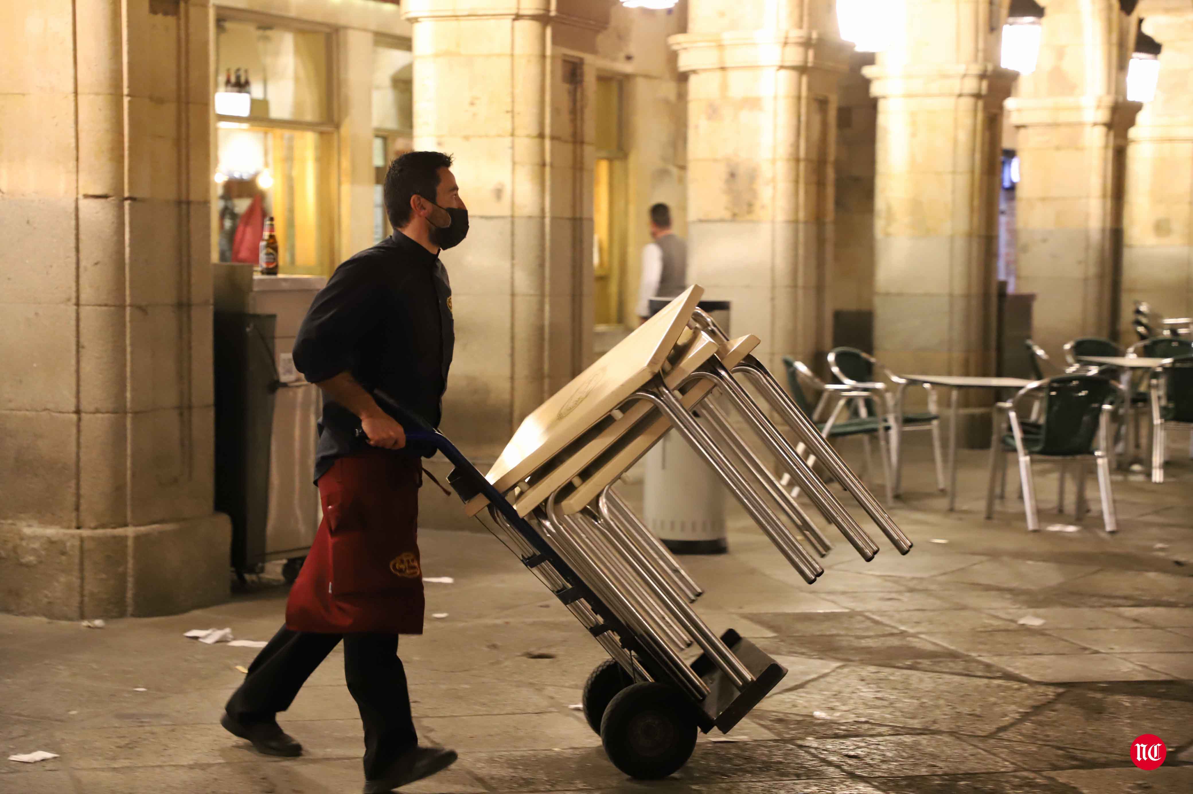 Un hostelero recoge la terraza en la Plaza Mayor de Salamanca.