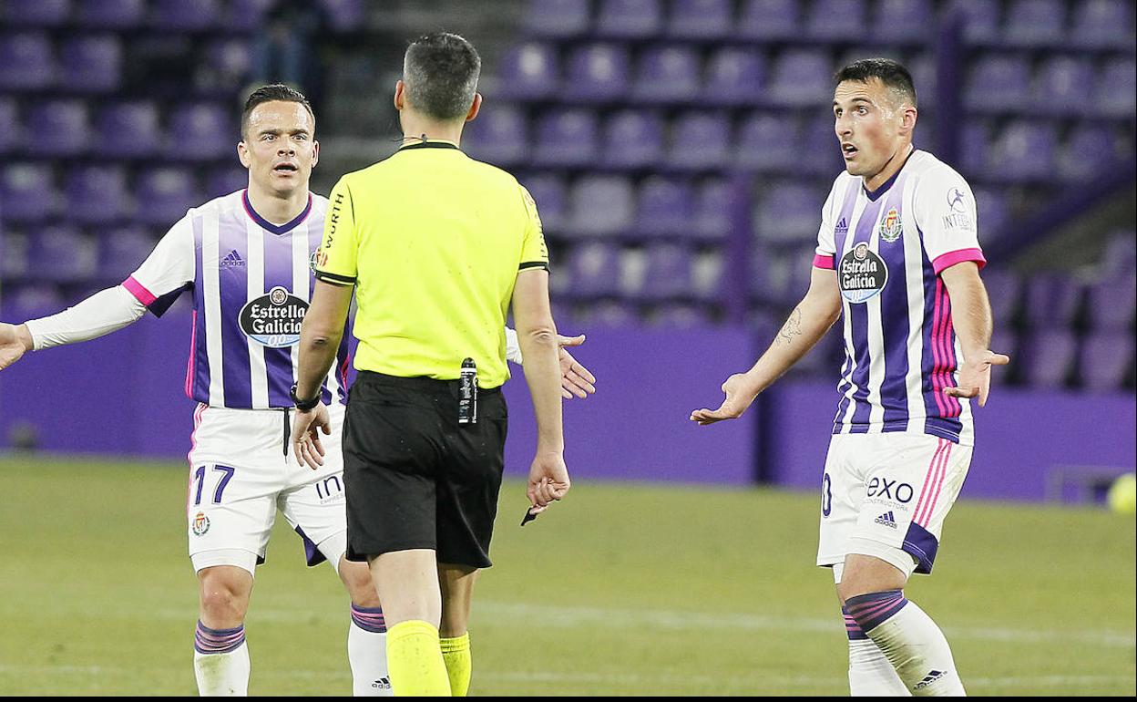 San Emeterio, a la derecha, protesta una acción junto a Roque Mesa al colegiado Jaime Latre. 