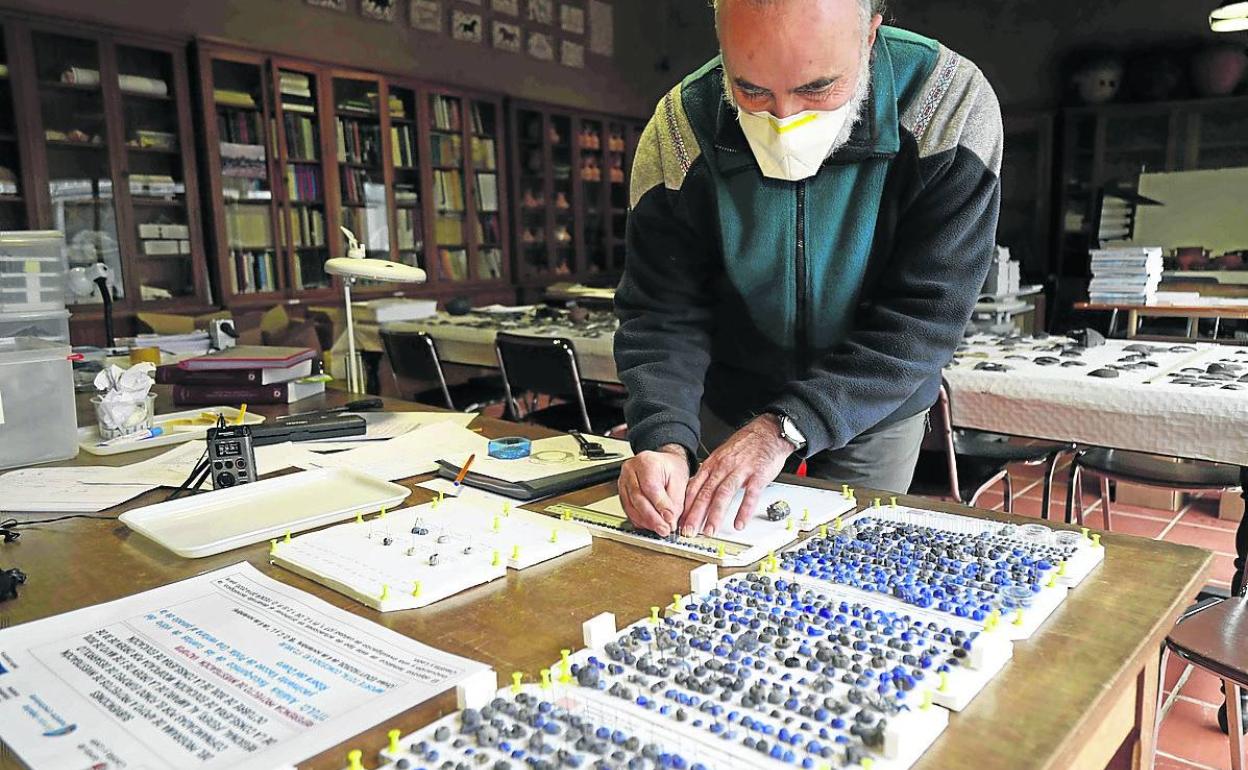 El profesor Carlos Sanz cataloga las cuentas de vidrio. 