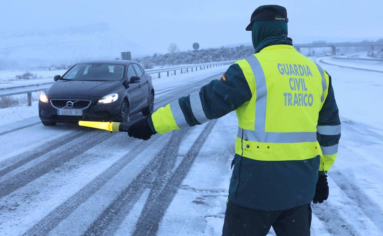 Un agente de la Guardia Civil regula el tráfico durante una nevada en la provincia de Palencia. 