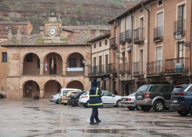 Imagen secundaria 1 - Calle vacía, sin peatones ni vehículos durante la mañana de ayer. El cartero transita por las cercanías del Ayuntamiento. Una persona aguarda su turno para entrar en la farmacia. 