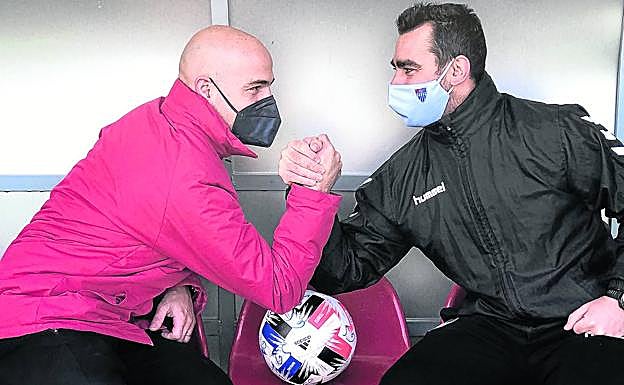 Los entrenadores de La Granja (i) y la Segoviana echan un pulso con el balón como punto de apoyo. 