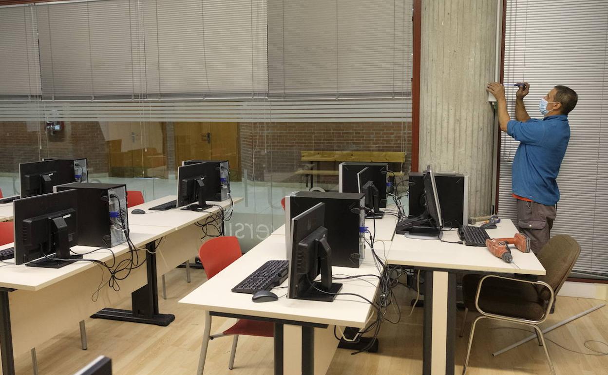 Un operario acondiciona un aula de un centro en Castilla y León. 