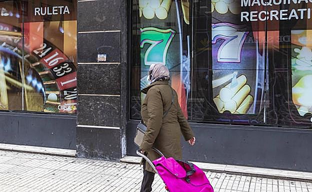 Una vecina pasa junto a un local de apuestas.