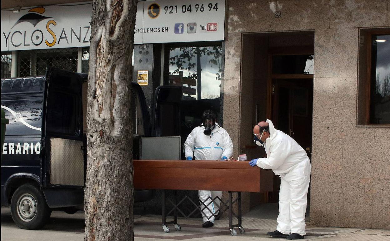 Servicios funerarios recogen un cadáver en la ciudad durante la pandemia. 