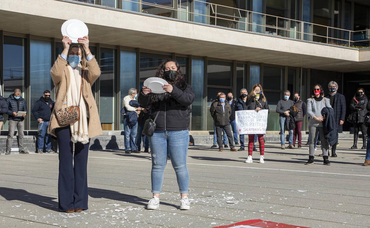 Dos hosteleras rompen platos frente a la Delegación Territorial de la Junta durante la concentración .