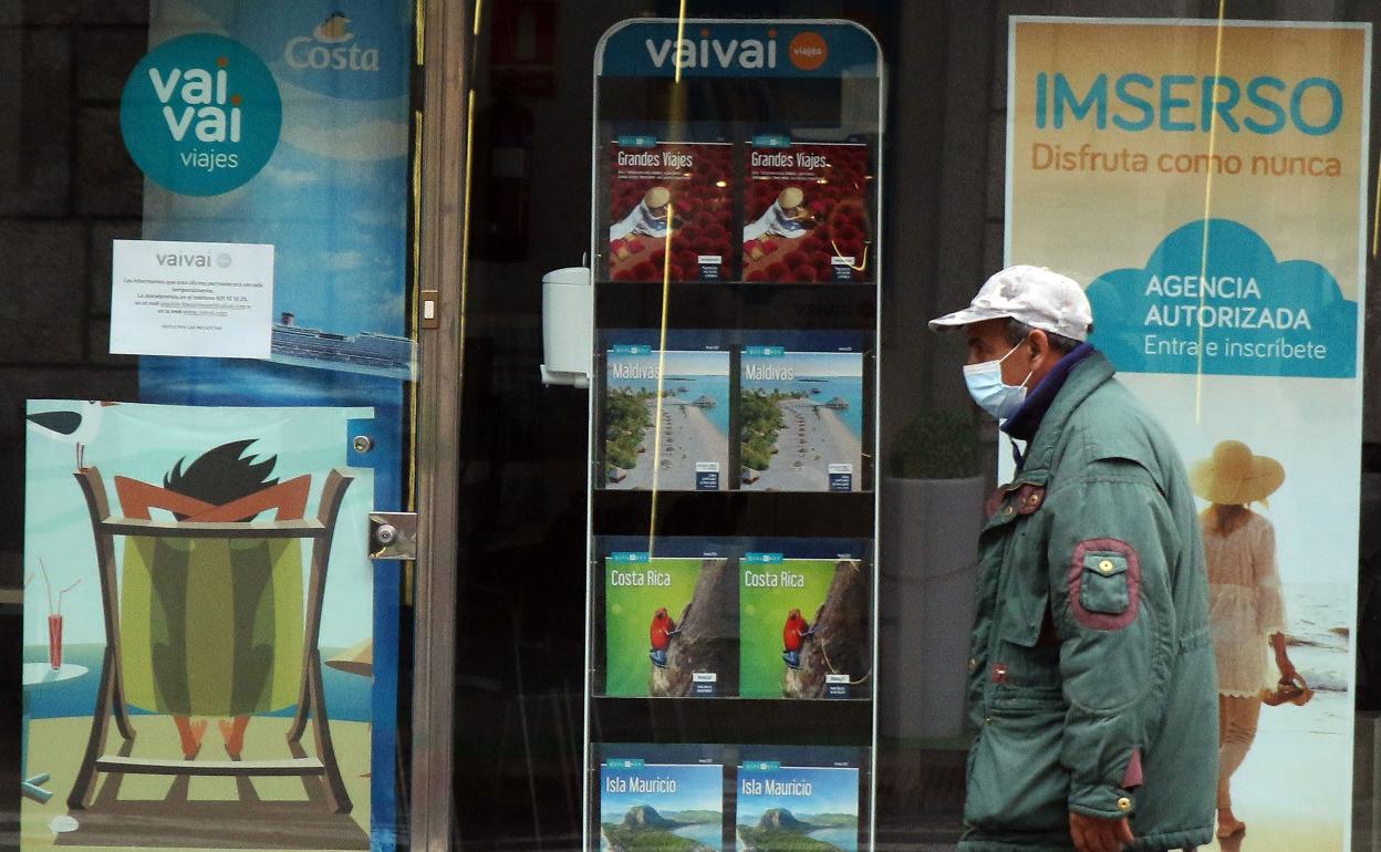 Un hombre pasa delante de una agencia cerrada, en Segovia.