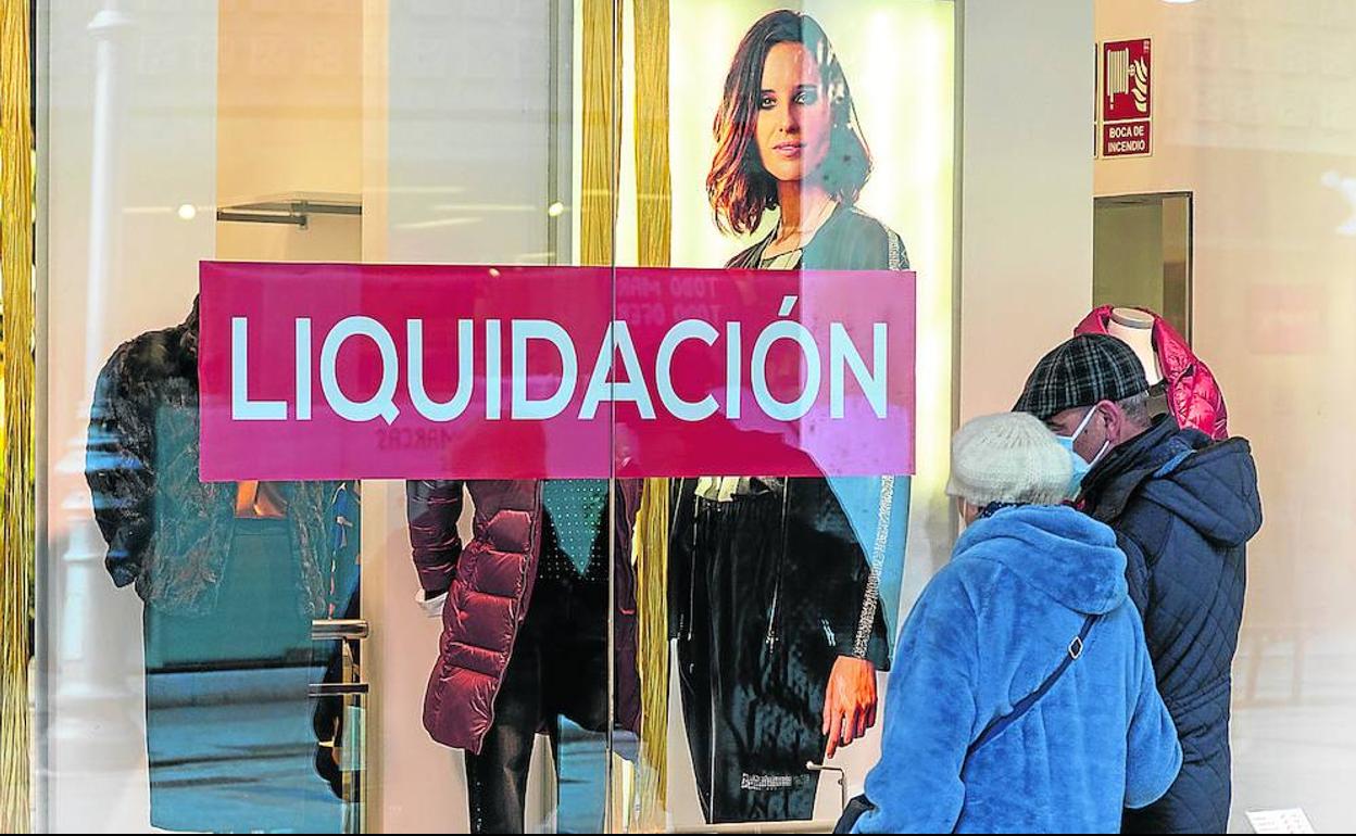 Escaparate de un comercio de Palencia, con un cartel de liquidación.