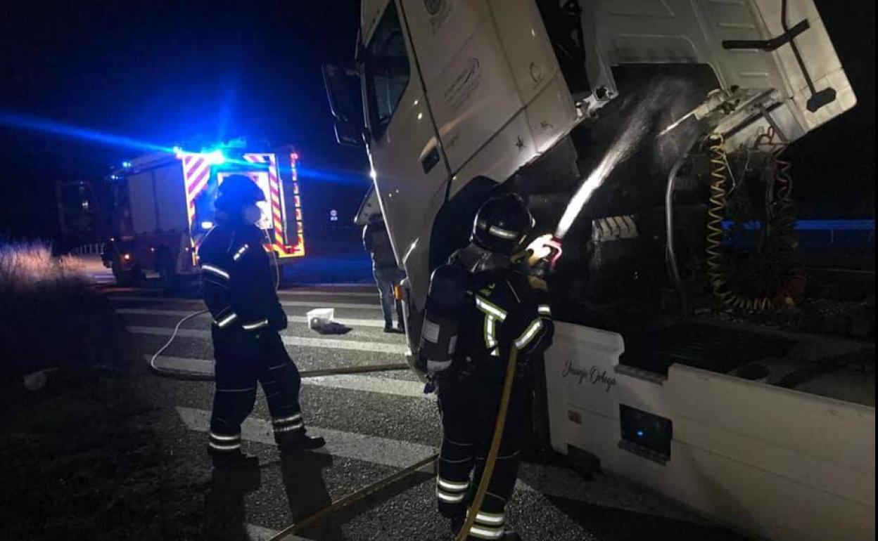 Los bomberos sofocan el fuego provocado en el motor del camión. 
