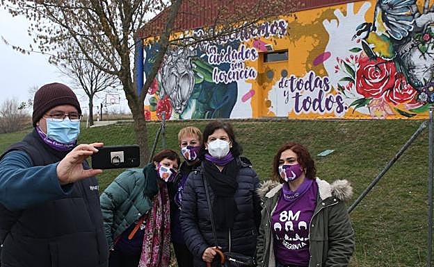 Imagen principal - Arriba, selfie ante el mural del 8-M realizado en el colegio Elena Fortún: Abajo, a la izquierda, exposición en la plaza de San Martín; y a la derecha, muestra en el ágora del campus de la UVA en Segovia. 