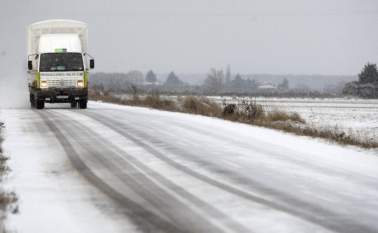 Un camión circula por una carretera nevada en la provincia de Burgos, en una imagen de archivo.