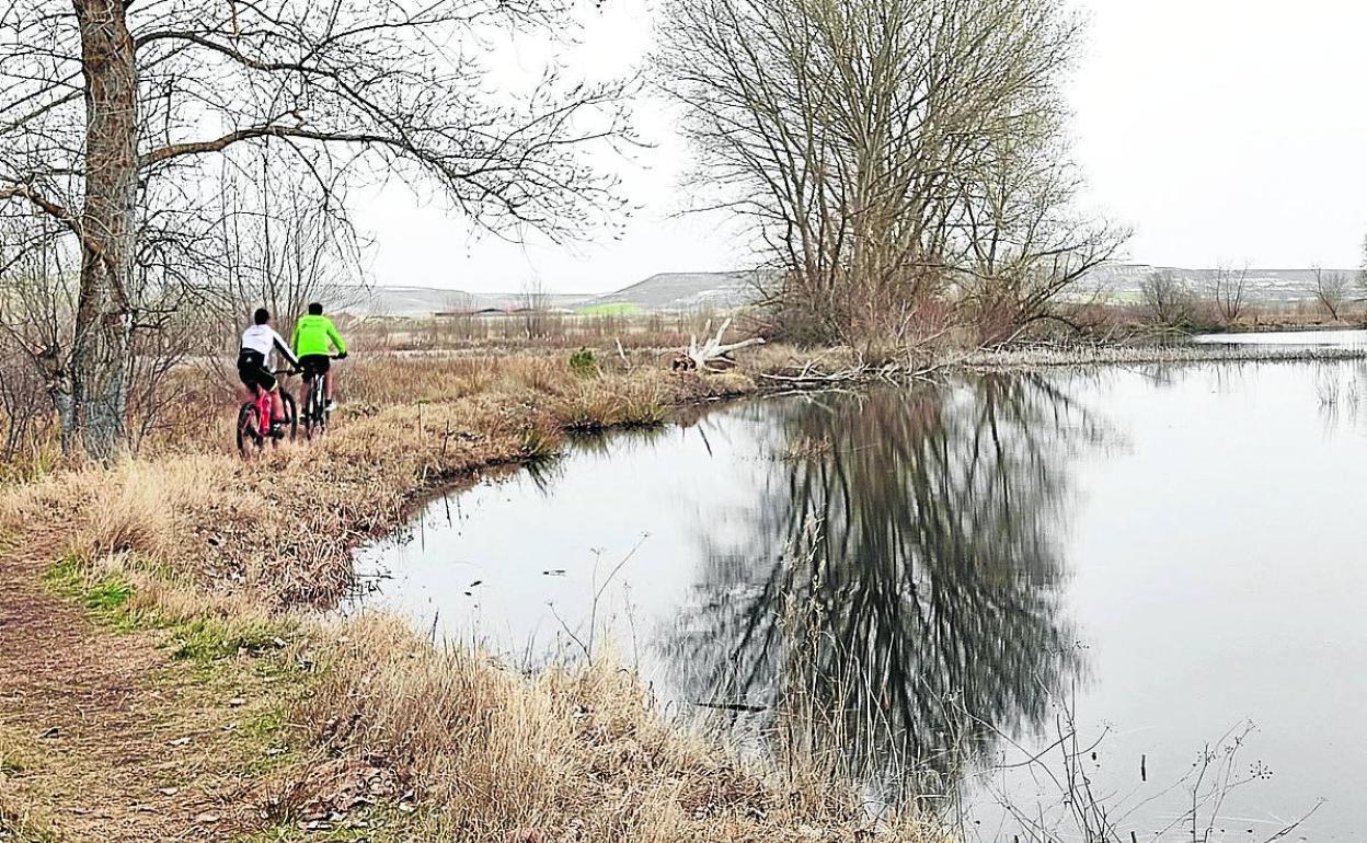 Dos ciclistas bordeando la laguna El Espadañal, uno de los parajes incluidos en las rutas. 