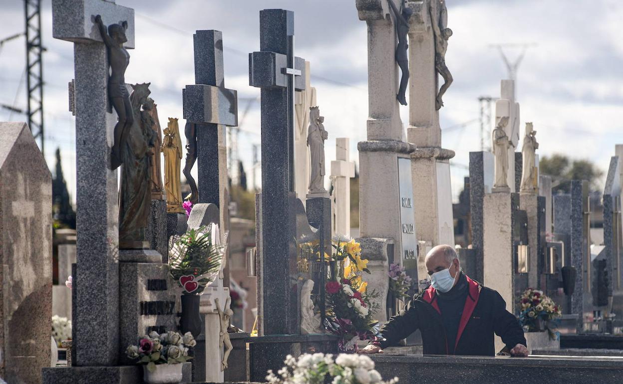 Un hombre visita una tumba en el cementerio de El Carmen. 