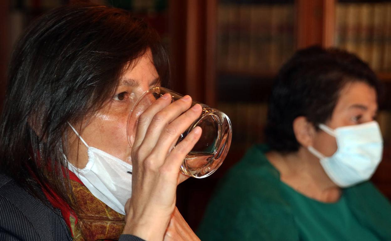 Gina Aguiar bebe un vaso de agua junto a la alcaldesa de Segovia, Clara Luquero, en la comparecencia de este miércoles. 