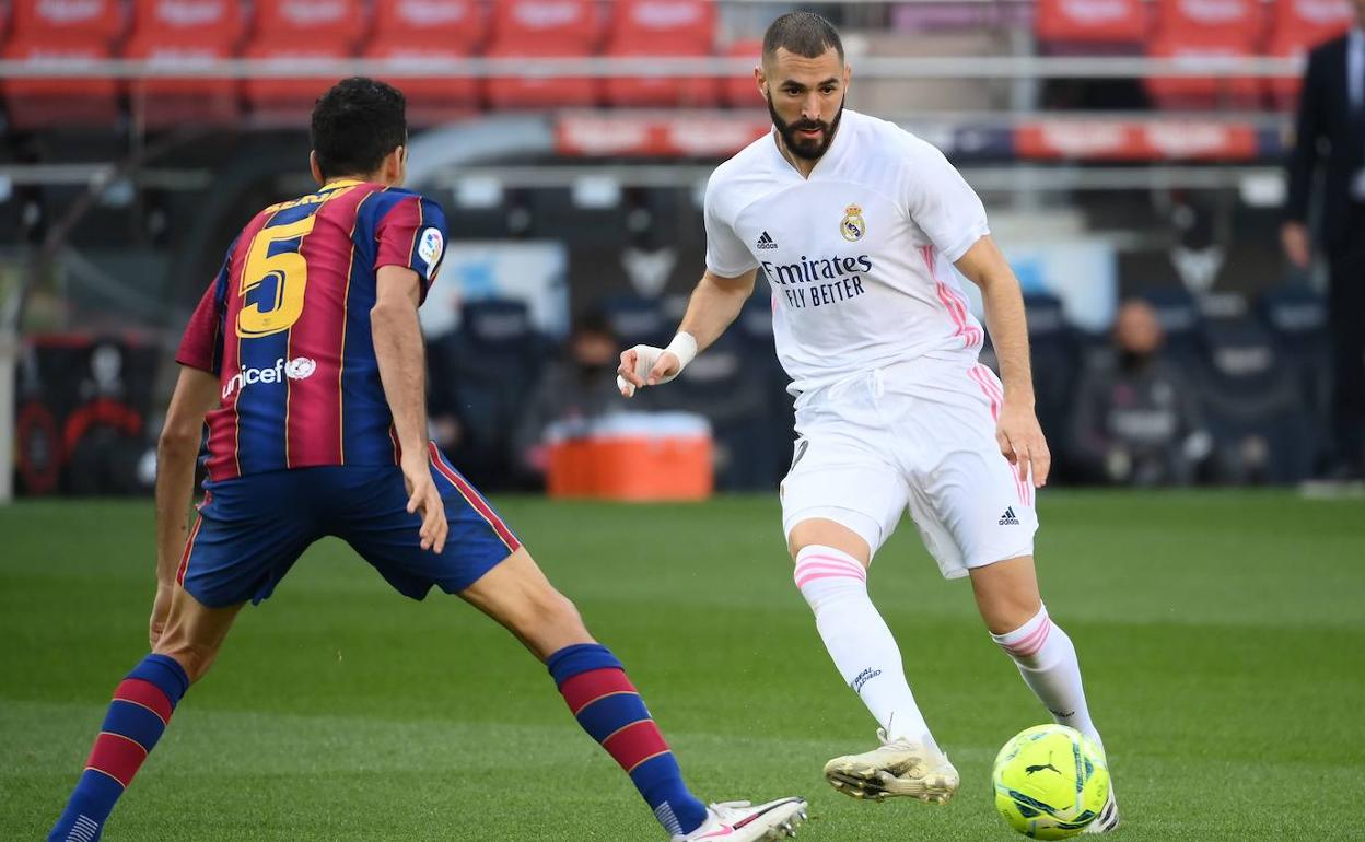 Benzema filtra un pase ante Busquets en una acción del clásico de la primera vuelta. 