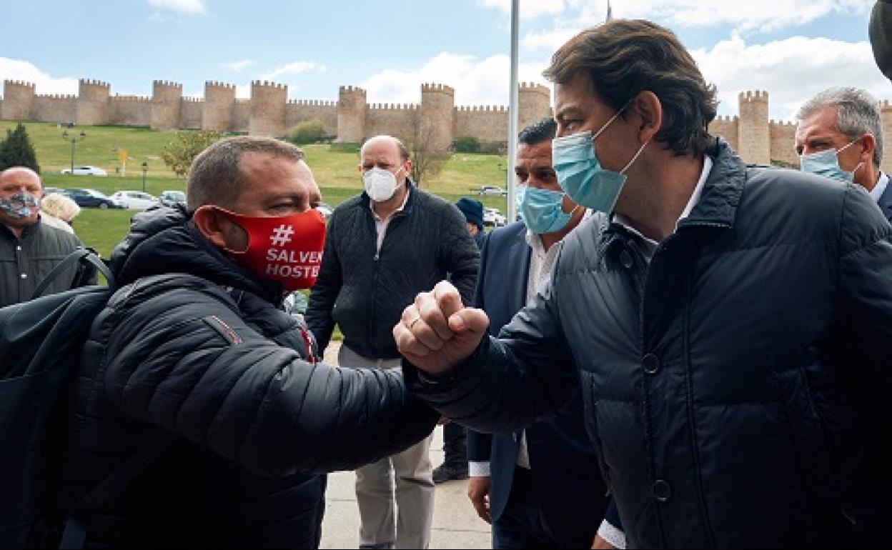 El presidente de la Junta de Castilla y León, Alfonso Fernández Mañueco (d), saluda al presidente de la Federación Abulense de Hostelería, Fernando José Alfayete (i), el pasado sábado antes de clausurar del XII Congreso Provincial del PP 