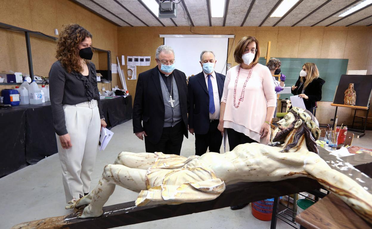 La presidenta de la Diputación, con el delegado diocesano de Patrimonio y el obispo, y la diputada de Cultura, observan un Cristo en restauración. 