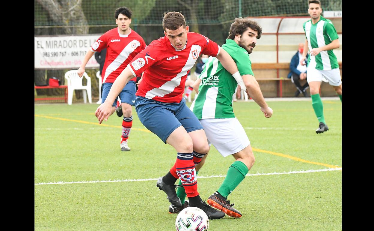 Pugna por un balón dividido entre dos jugadores del Simancas y Betis. 