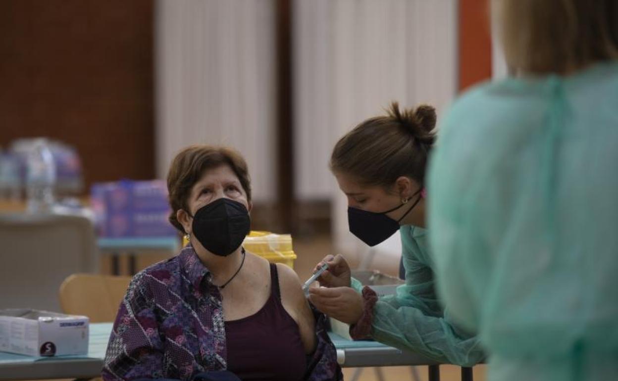 Una mujer recibe la primera dosis de la vacuna contra la covid-19 en Sevilla (Andalucía, España) 
